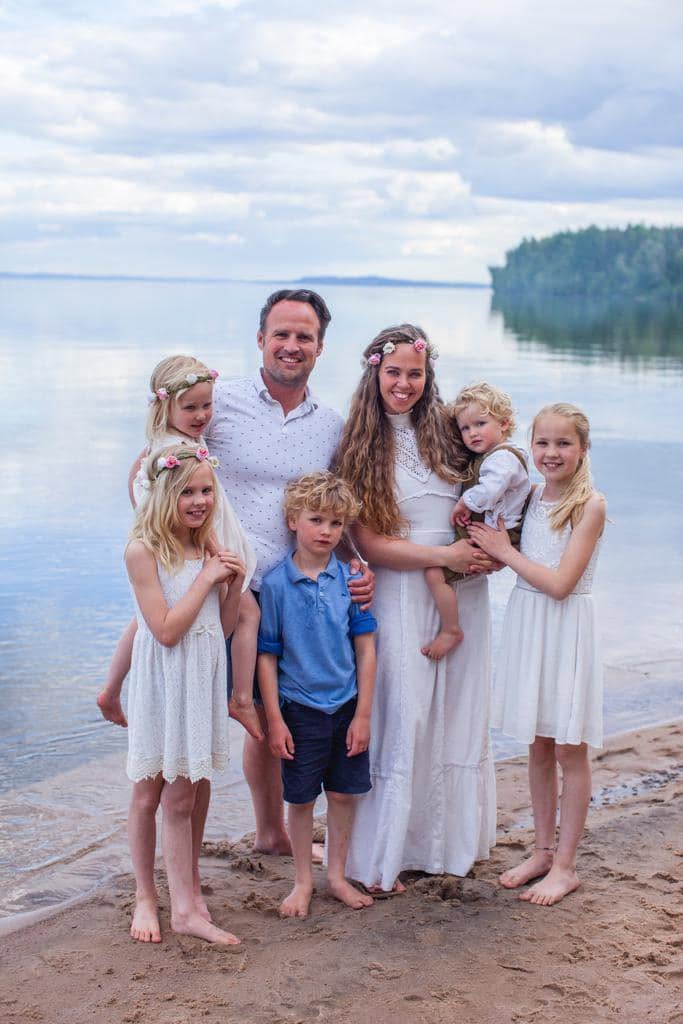 The Heroes Family: father, mother and five children on the shore of a lake